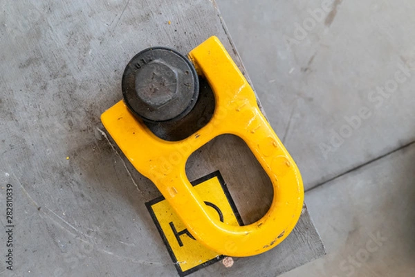 Fototapeta yellow eyebolt in an industrial environment for connection to a lifting hook for heavy loads