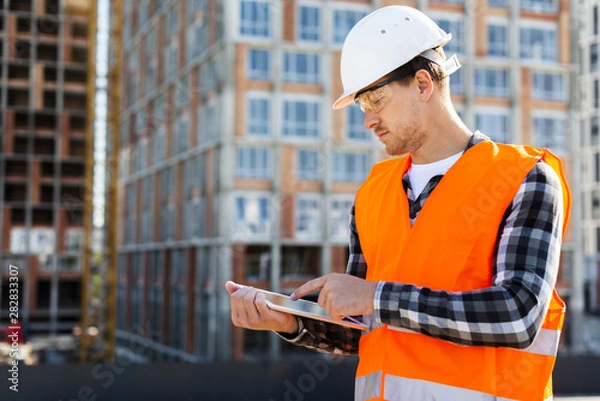 Fototapeta Medium shot side view construction engineer using tablet