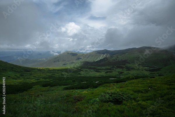 Obraz rain high in the mountains floods half the panorama of the mountains