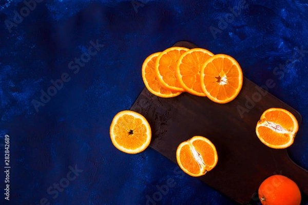 Obraz Fresh sliced oranges on wooden board