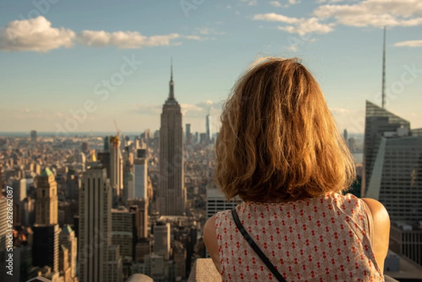 Fototapeta Blonde tourist taking a picture of the Empire State
