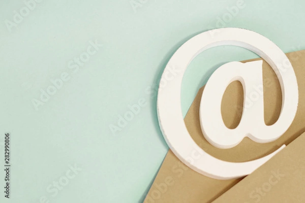 Fototapeta brown envelope with e-mail at sign on blue background
