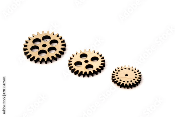 Fototapeta three wooden gears of different size isolated on white background