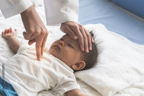 Fototapeta The doctor is using two fingers to press down in the middle of the baby's chest, which is CPR in the case that the child stops breating, to health care and insurance concept.