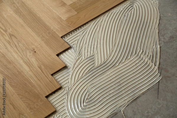 Fototapeta Construction in a renovated room installation of parquet