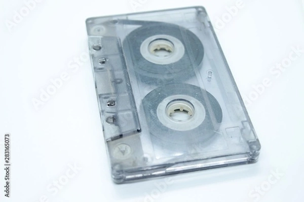 Fototapeta The audio cassette is located on a white background