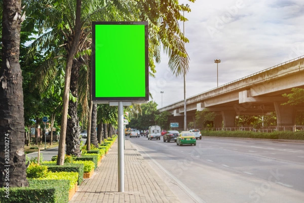 Fototapeta Blank billboard with chroma key green screen for your text for advertisement side on street.