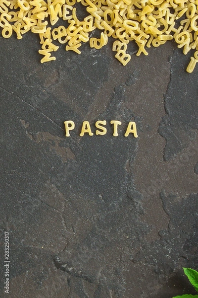 Fototapeta Pasta Alphabet and ingredient for sauce (set of ingredients, raw pasta) serving second course. top food background. copy space