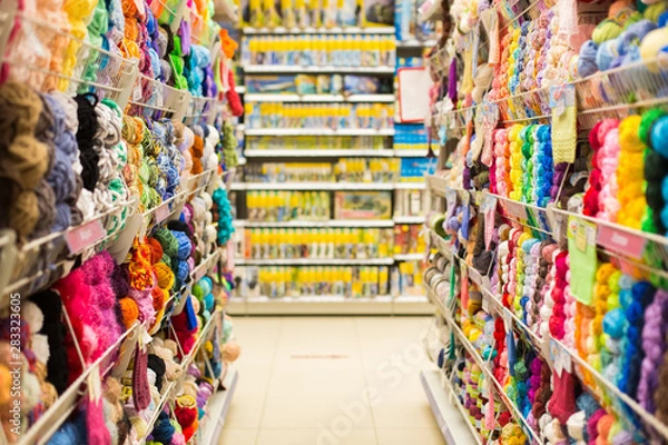 Obraz Shelves with colorful yarn balls at knitting store. Shop Needlework, counters with colored yarn. Shopping wool balls