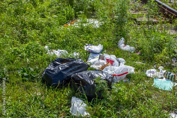 Fototapeta Traces of debris, plastic bags and garbage that fell on the train route