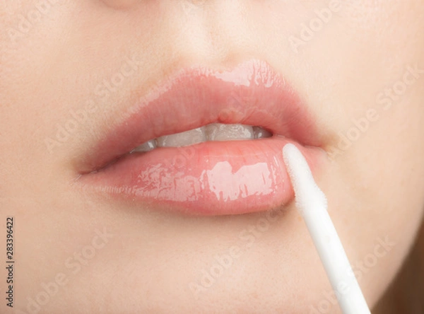 Obraz  Woman Apply Moisturizing Lip Gloss
