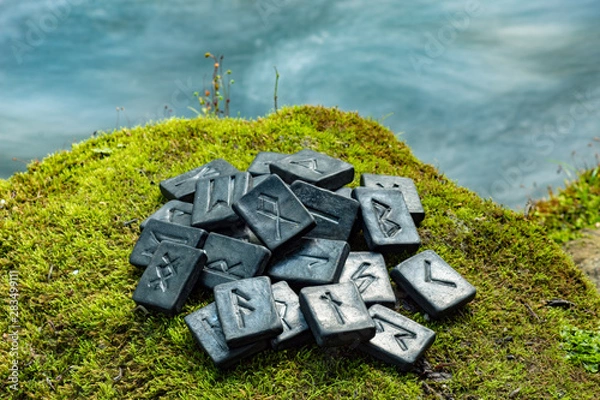 Fototapeta 24 Norse runes on the green grass and the evening river background