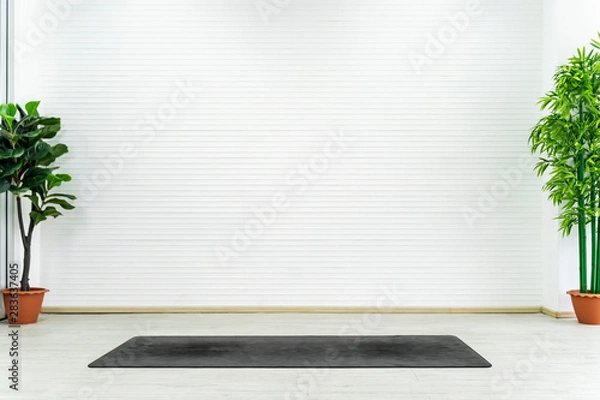 Fototapeta Empty room with yoga mat on floor with white wall. Can use for backdrop and background.