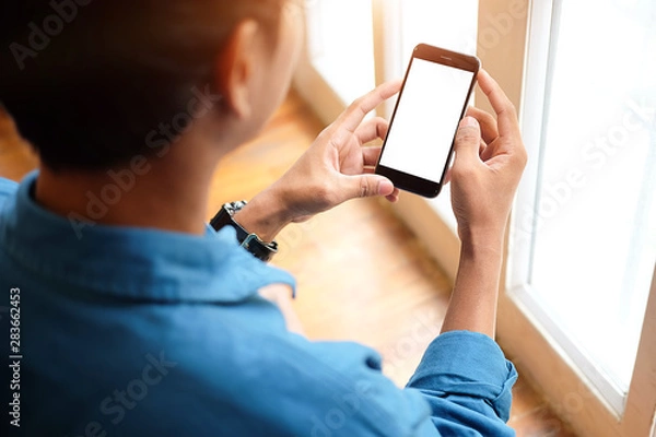 Fototapeta Cropped shot view of man hands holding smart phone with blank copy space screen for your text message or information content, female reading text message on cell telephone during in urban setting. 