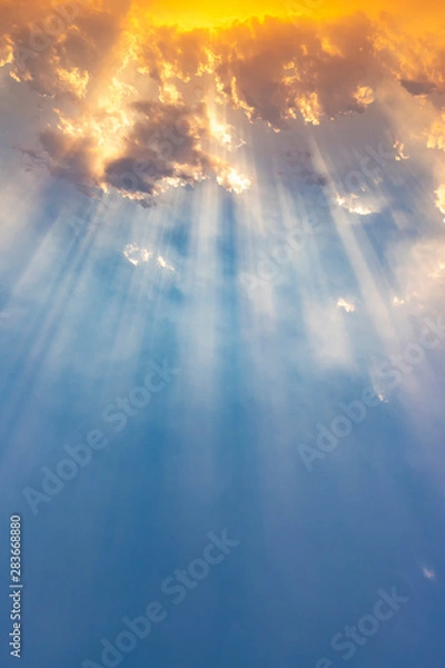 Fototapeta Besutiful ray of sunlight breaking through clouds at sunset.