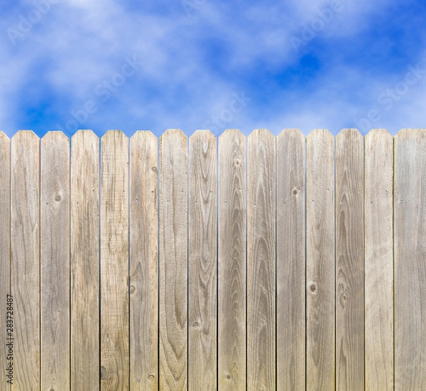 Obraz Whitewashed rustic wood privacy fence with blue sky and clouds
