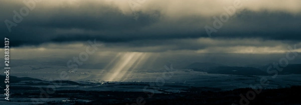 Fototapeta Mountains view, sun rays goues from the cloudy ski.