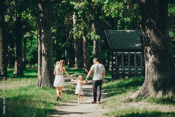 Obraz Happy family with two children have rest on a walk outdoors.