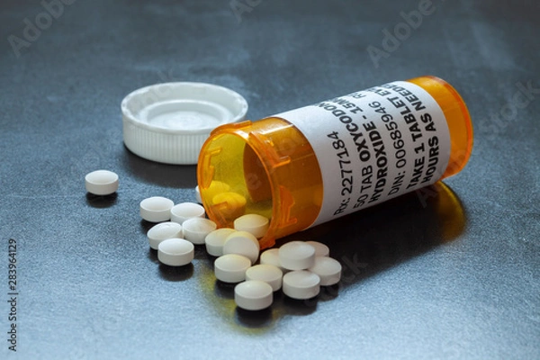 Fototapeta Prescription bottle with backlit Oxycodone tablets. Oxycodone is a generic prescription opioid. A concept of the opioid epidemic crisis