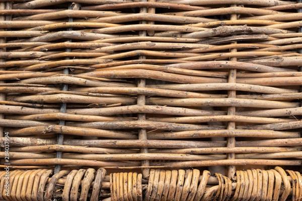 Obraz Horizontally intertwined brown willow rods with small vertically intertwined rods at the bottom.