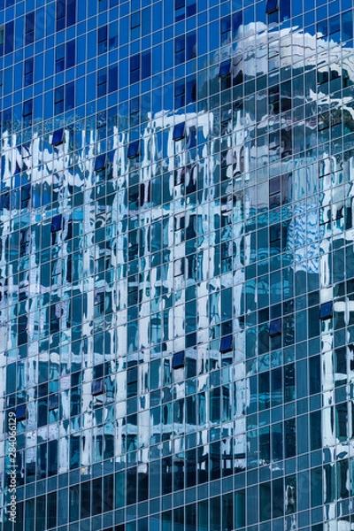Obraz Closeup reflection of buliding in glass fasade of skyscraper. Business concept of architecture. Blue tone.