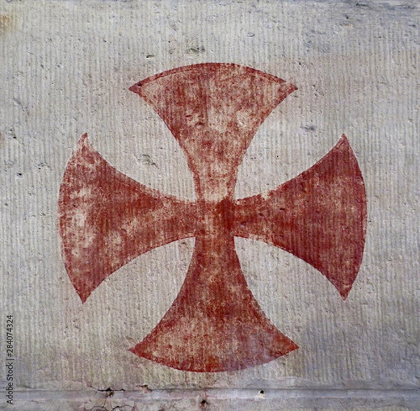 Fototapeta red knights templar cross painted on a wall in a church, close