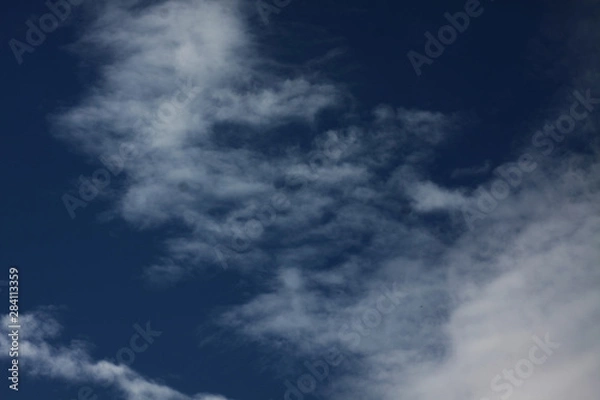 Obraz White clouds on dark blue background