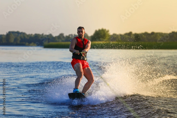 Fototapeta Man making waves on wakeboard 