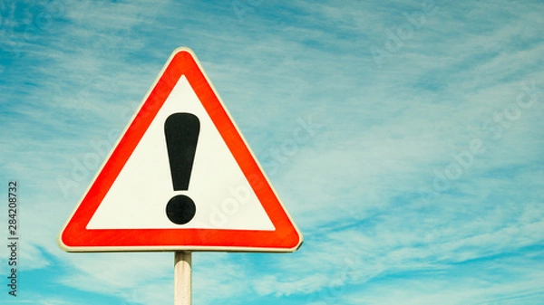 Fototapeta Exclamation point of attention against the sky. triangular sign. Danger, warning.