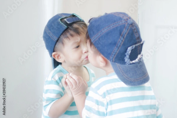 Fototapeta Cute little boy looking at mirror , kid self talk via mirror , play with salt