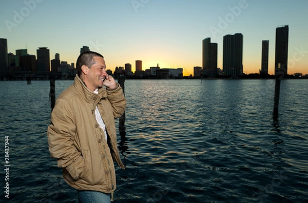 Fototapeta Handsome Hispanic man in a lifestyle pose with a mobile phone
