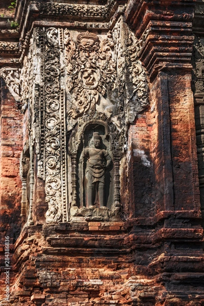 Fototapeta Siem Reap, Kambodża. Rzeźbiony kamienny strażnik chroni starożytne ruiny i wieże świątyni Bayon w Preah Khan (Roluos Group)