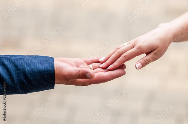 Fototapeta Bride and groom hands drawning to each other
