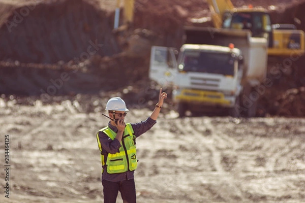 Fototapeta Portrait of asian male supervisor in mine soil field location operation a radio or walkie talkie