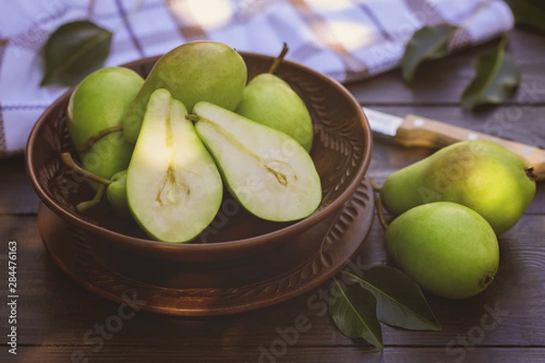 Fototapeta fresh green ripe pears in the bowl close-up. background with pears in the garden.