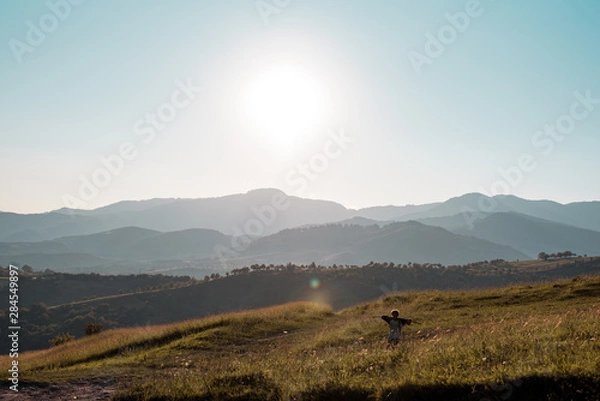 Obraz Big hills with sun over them.