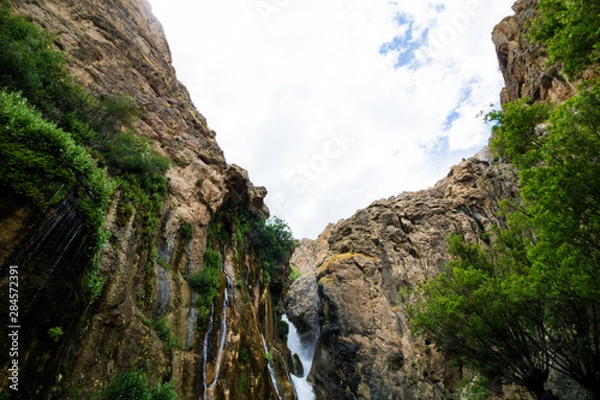 Obraz waterfall in the mountains with clouds