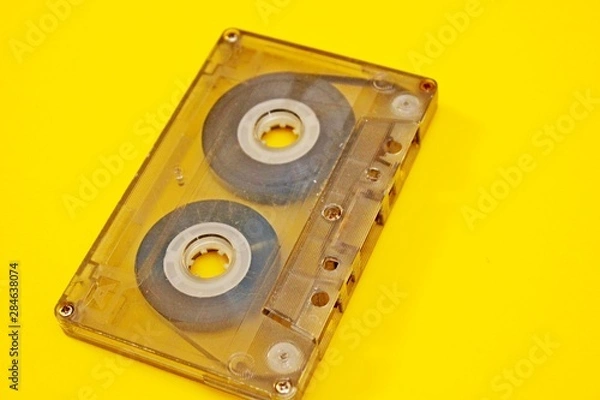 Obraz Old transparent audio cassette located on a yellow background