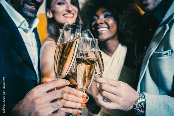Obraz Men and women celebrating party while clinking glasses with sparkling wine