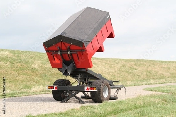 Obraz Roter Spezialanhänger mit grauer Plane auf der Wiese