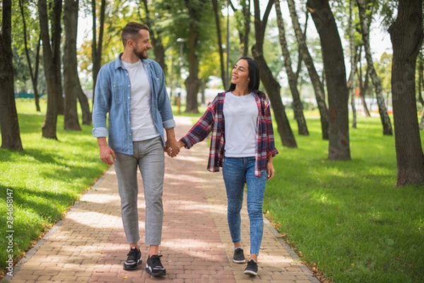 Fototapeta loving couple walking in the park and hugging, beautiful guy and girl