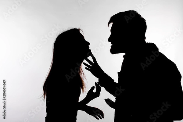 Fototapeta Relationship difficulties, conflict and abuse concept - man and woman face to face screaming shouting each other dispute silhouette isolated on white background