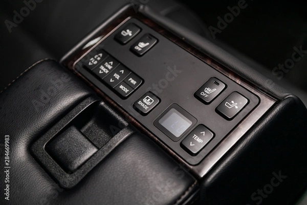 Obraz Close-up on the shade lock, seat heatting, seat adjustment , parking radar,Temperature regulator  switch control buttons,  automatic adjust level dashboard. modern car interior: parts, buttons, knobs.