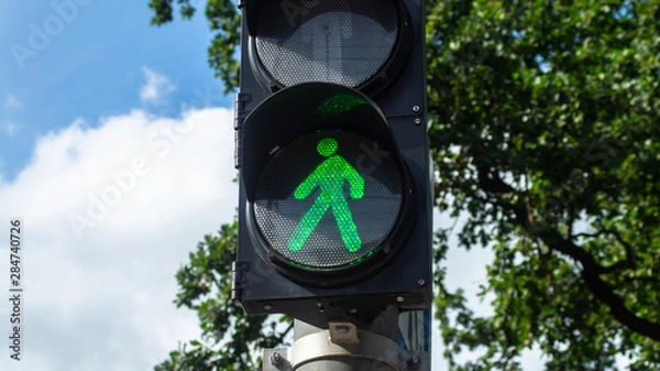 Fototapeta Pedestrian traffic light green color light walking man icon sunny bright
