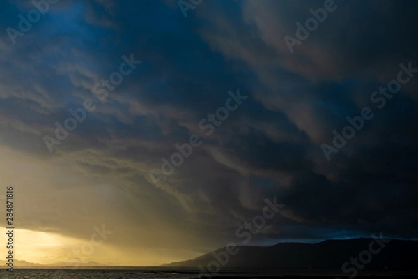 Obraz Light in the Dark and Dramatic Storm Clouds background,before the rain