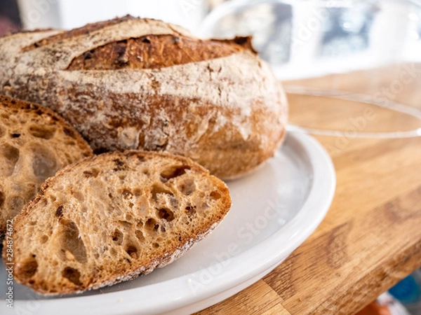 Fototapeta Sourdough bread. Close focus on cut sourdough bread with background bokeh copy space.