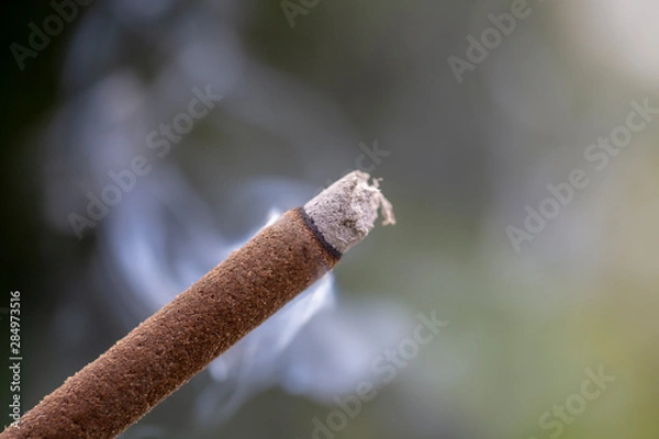 Fototapeta Incense stick burning with smoke, closeup . Island Bali, Ubud, Indonesia
