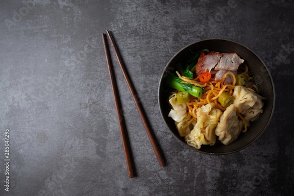 Fototapeta Egg noodle with red roasted pork and wonton on table.