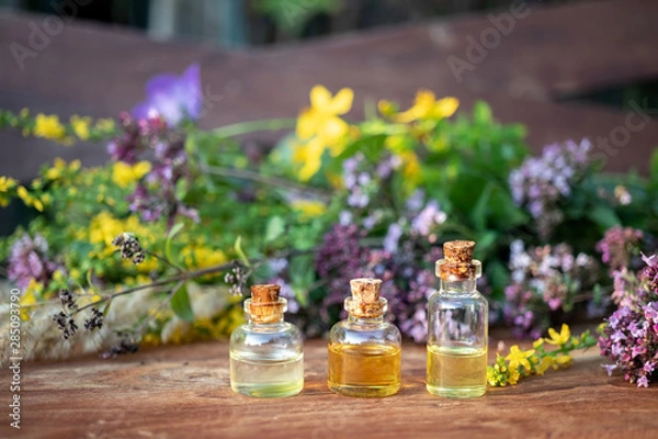 Fototapeta Bottles of essential oil with a mix of flowers