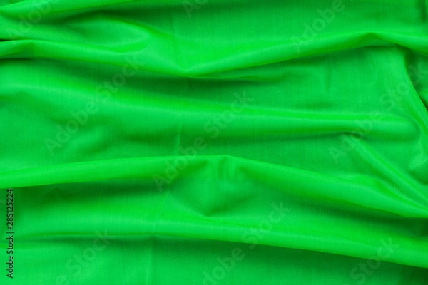Obraz Background in the form of material from bright green nylon with horizontal folds, top view